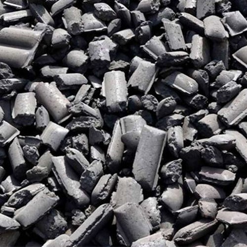 Close-up of high-density HBI briquettes showing metallic sheen and compacted texture