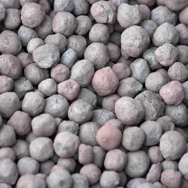 Bulk iron pellets stored in a large industrial silo or hopper.