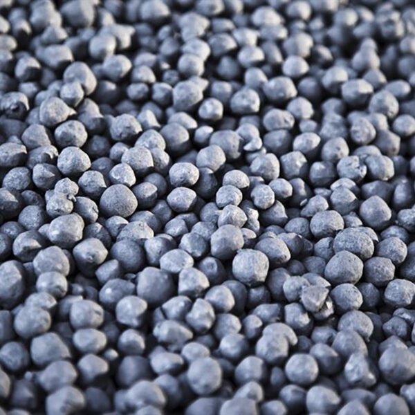 Bulk iron pellets stored in a large industrial silo or hopper.