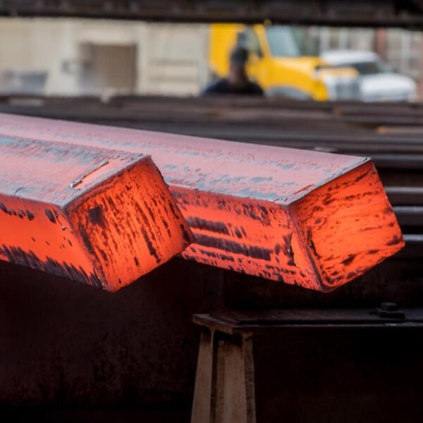 Steel billets are often stored in rows on the factory floor or in an open yard, ready for further processing.