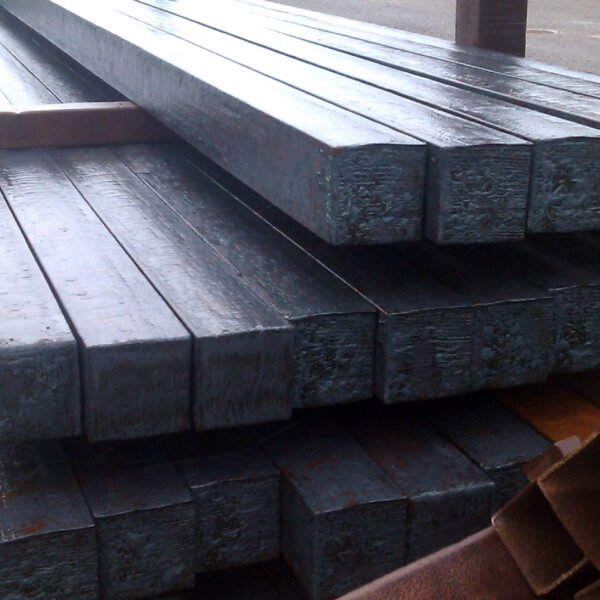 Steel billets are often stored in rows on the factory floor or in an open yard, ready for further processing.