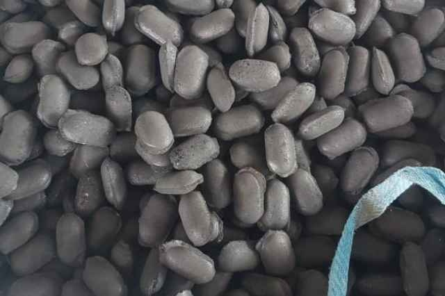 top view of a pile of iron close up a man holding a pile of iron briquettes
