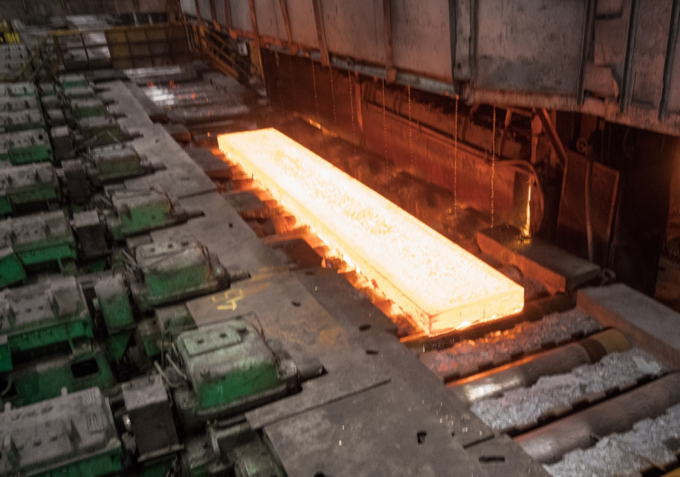 glowing hot steel slab in a factory production line