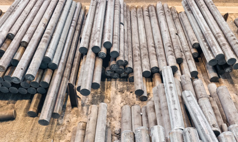 round billets stacked in a factory yard