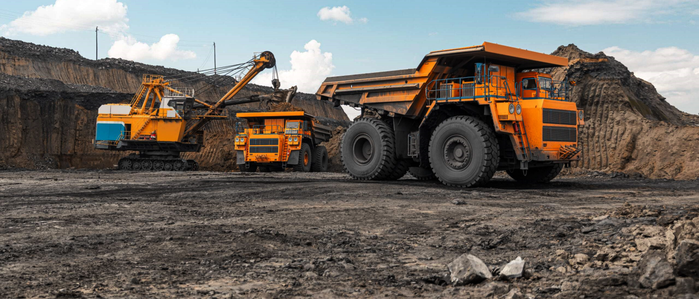 a yellow dump truck and other heavy machinery in a quarry